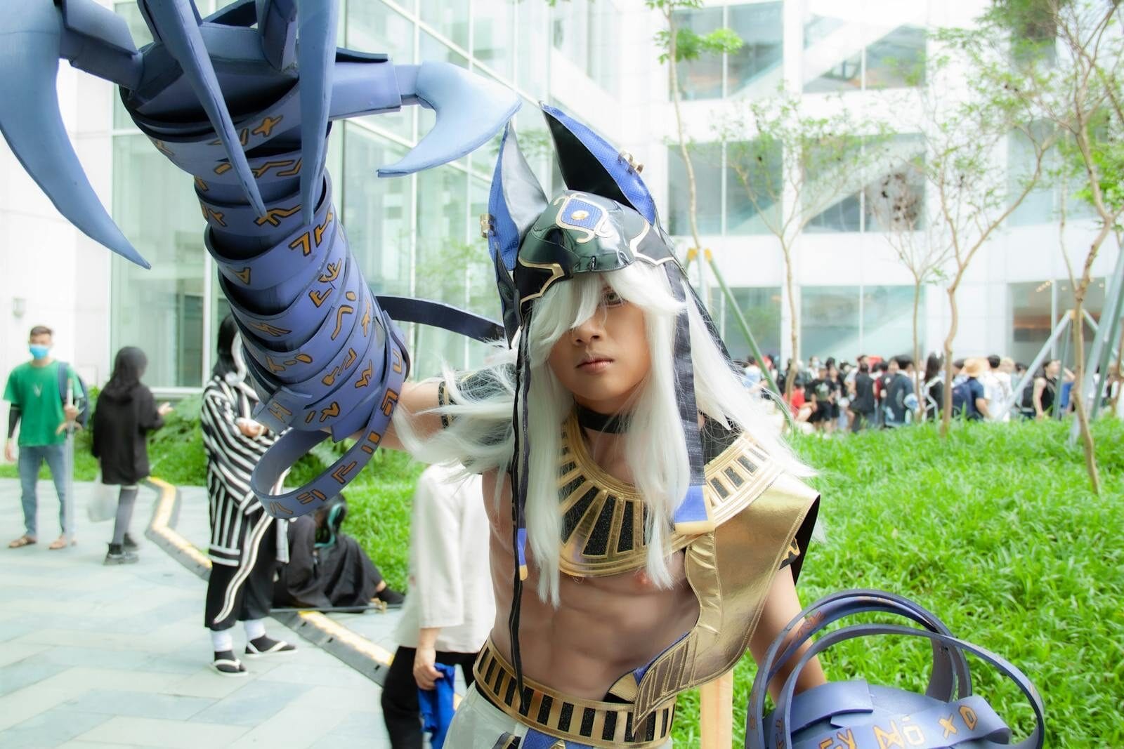 Young adult in cosplay costume at outdoor event with futuristic armor.