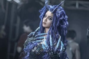 A captivating fantasy cosplay portrait featuring a character with purple hair, horns, and clawed hands, showcasing intricate design and creativity.