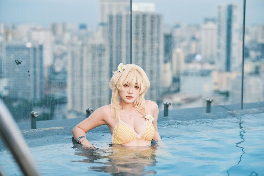 Cosplaying Woman In Yellow Bikini Enjoying A Rooftop Pool With City Skyline Backdrop.