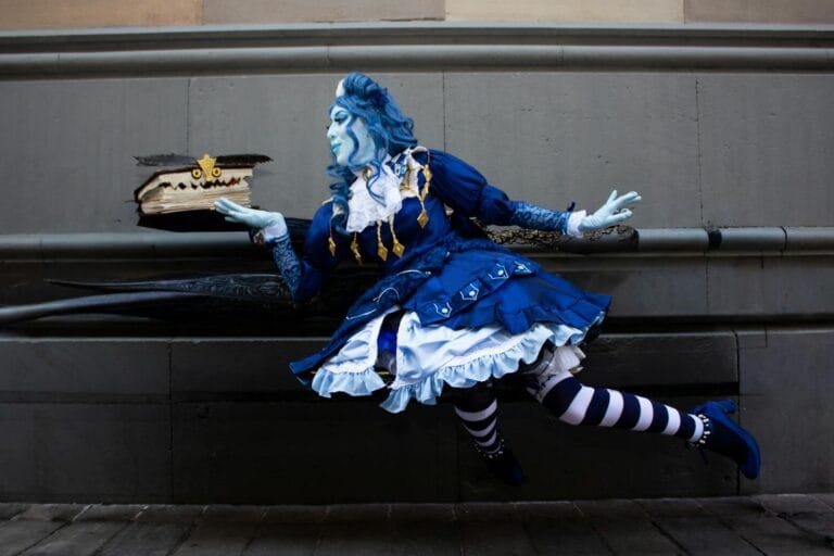 A Vibrant Blue-Themed Fantasy Cosplay Scene Featuring A Whimsical Character With A Floating Magical Book.